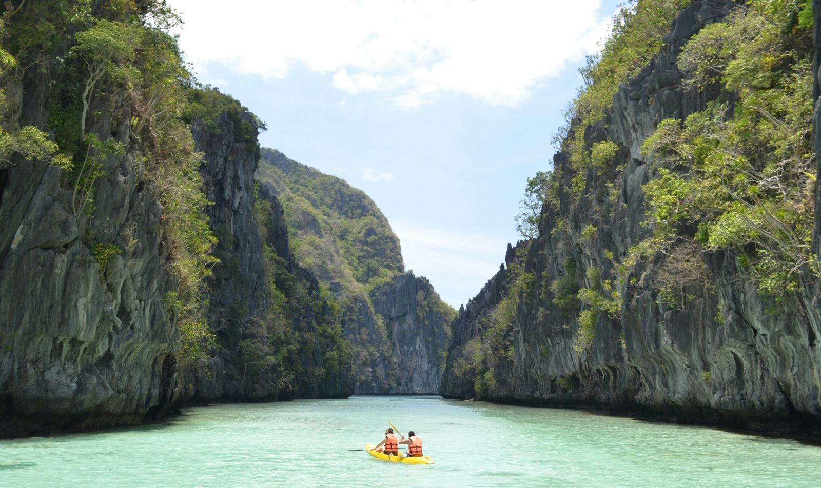 Kayak entre deux parois calcaires dans l'eau claire du Big Lagoon, El Nido